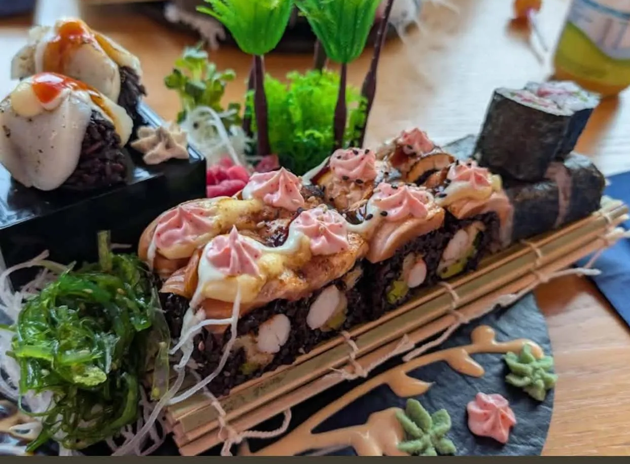 Mikado Special Roll mit flambiertem Lachs auf schwarzem Reis